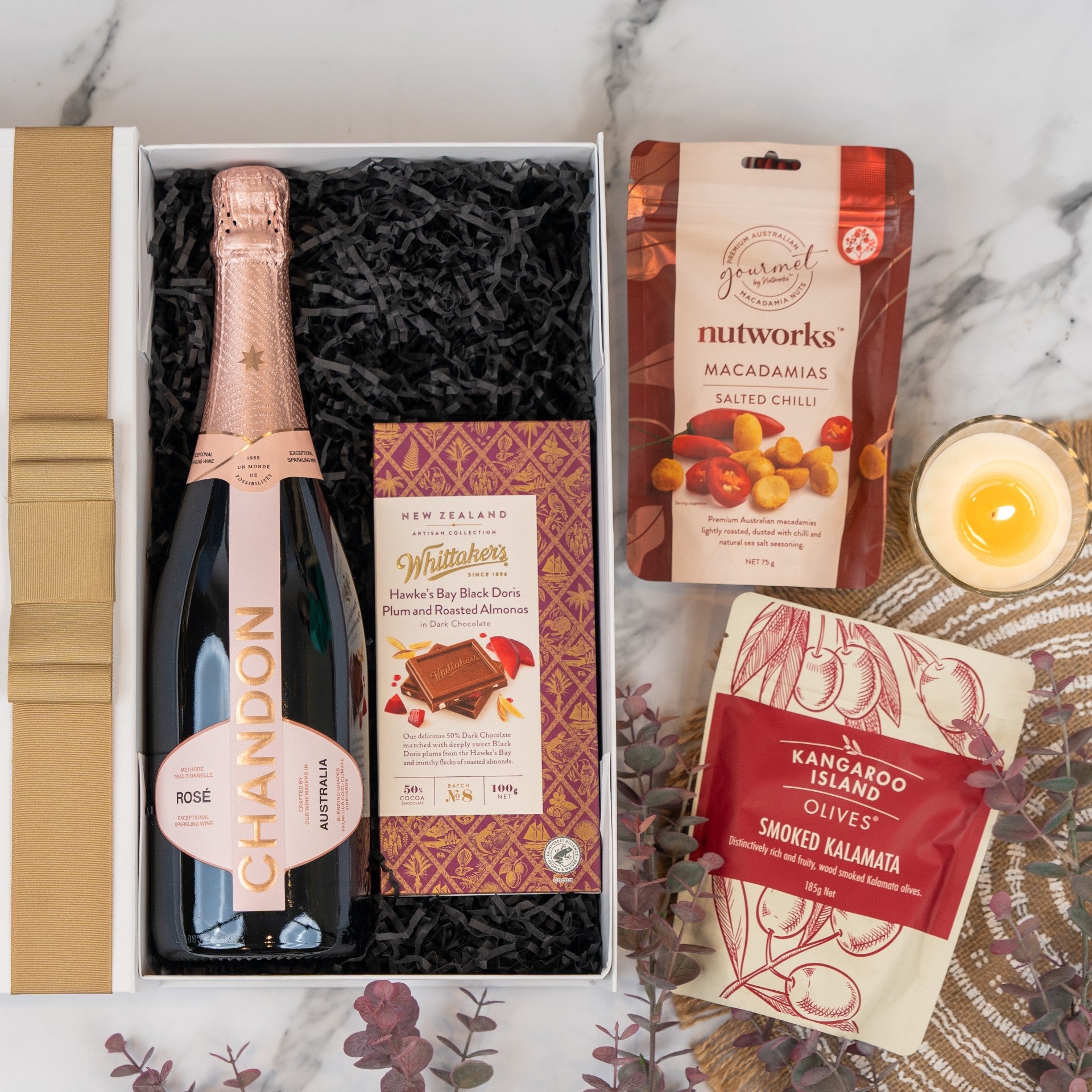 Elegant Chandon Rosé hamper with smoked olives, spicy macadamias, and plum-almond chocolate for a luxurious treat.