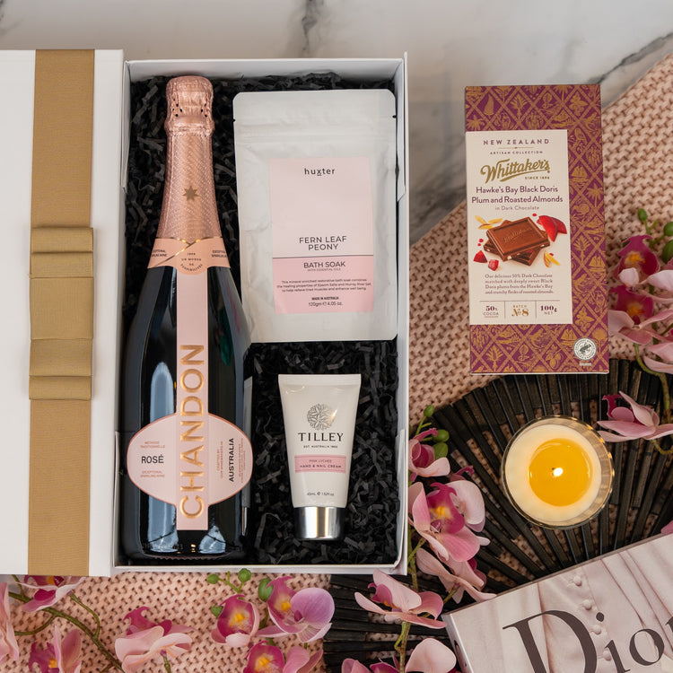 Luxurious pampering with Chandon Rosé, bath soak, hand cream, and fine chocolate. Perfect for relaxation and indulgence.